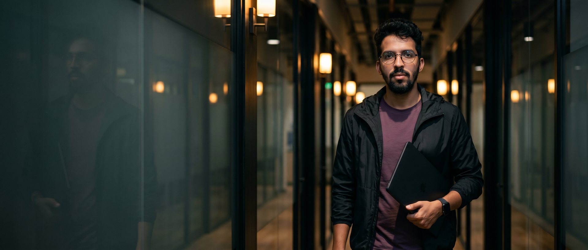 João Guirunas com notebook no corredor